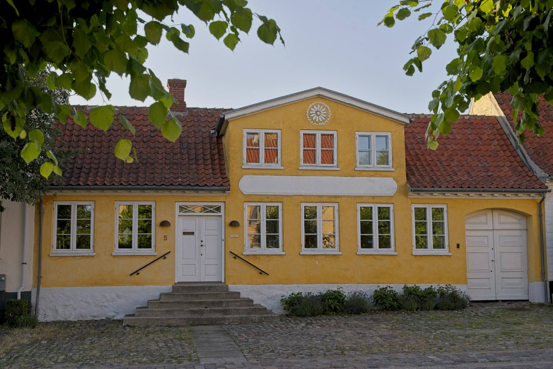 Gult dansk hus med rødt tegltag
